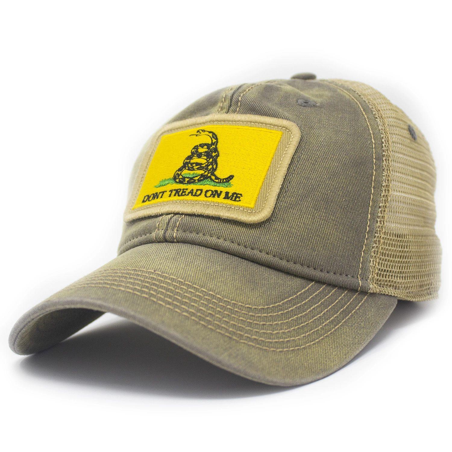 Grey trucker hat with khaki mesh back panels and tan stitching laying. Ballcap is embroidered with a patch of the Gadsden flag, the patch has a yellow background with a snake coiled in grass and the words Don't Tread On Me
