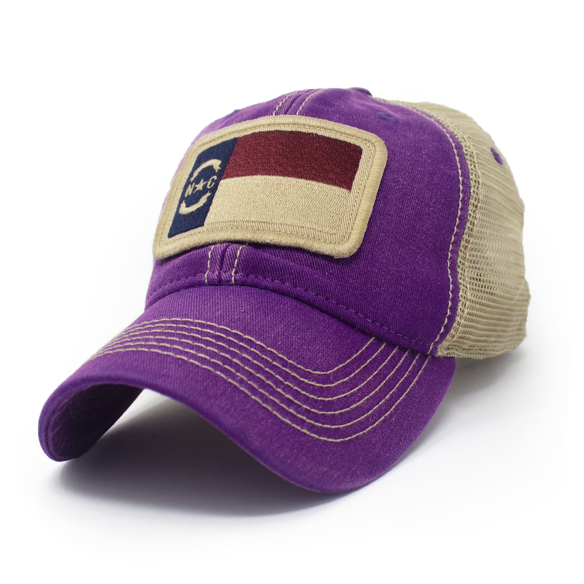 Trucker hat with khaki colored mesh backing, purple cotton front panel and bill with tan stitching. Ballcap has an embroidered patch of the North Carolina flag in in the center.